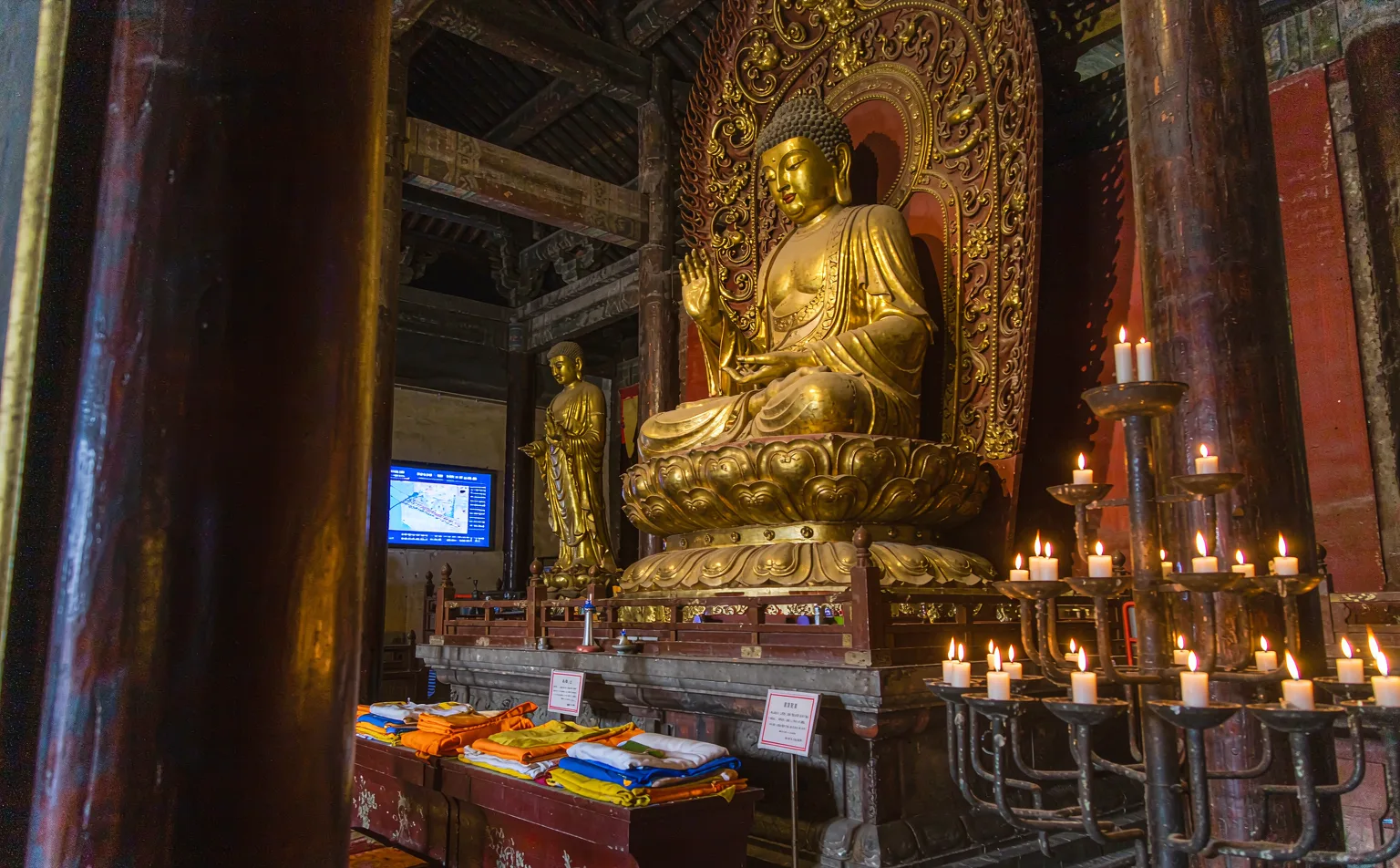 Golden Buddha statue and candles inside Wenshu Monastery