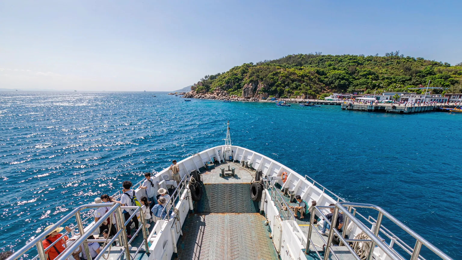 Ferry approaching West Island with passengers on deck