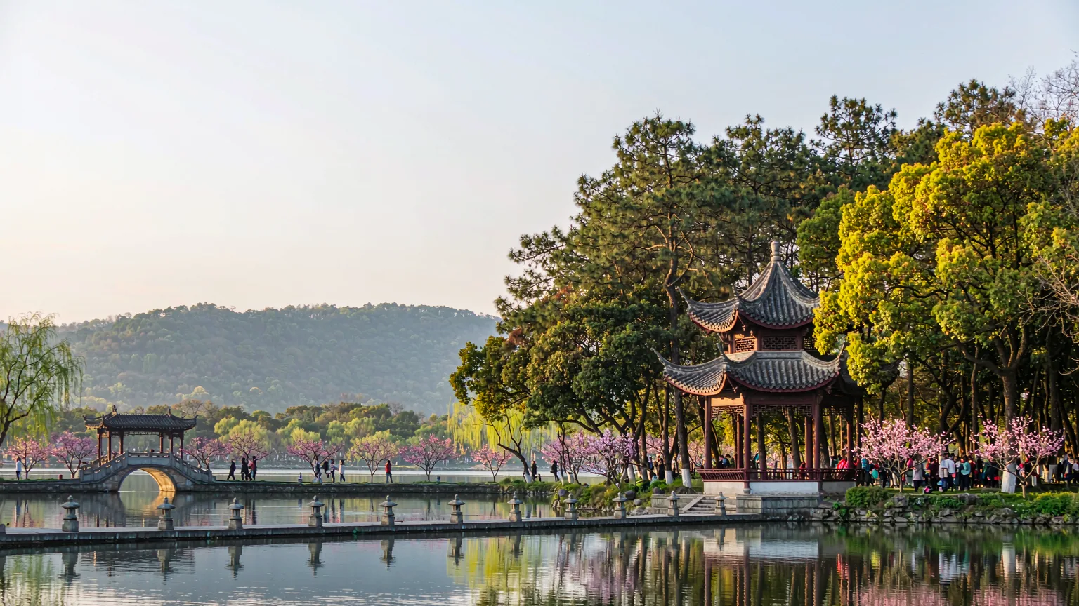 Springtime West Lake with Su Causeway, peach blossoms, and willow trees