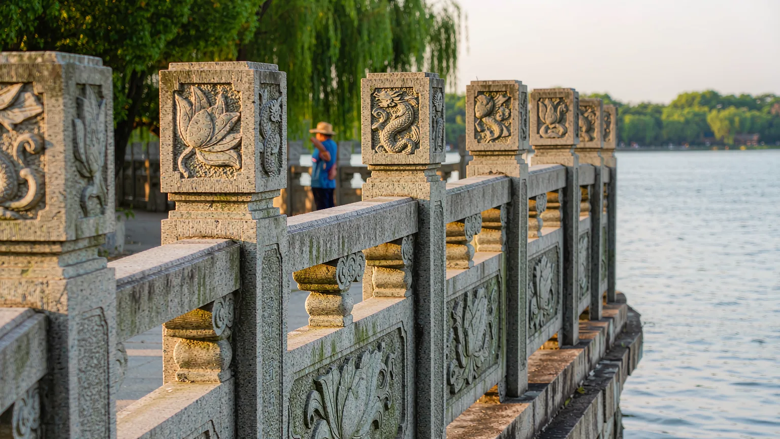 Detailed stone carvings on a bridge railing at West Lake