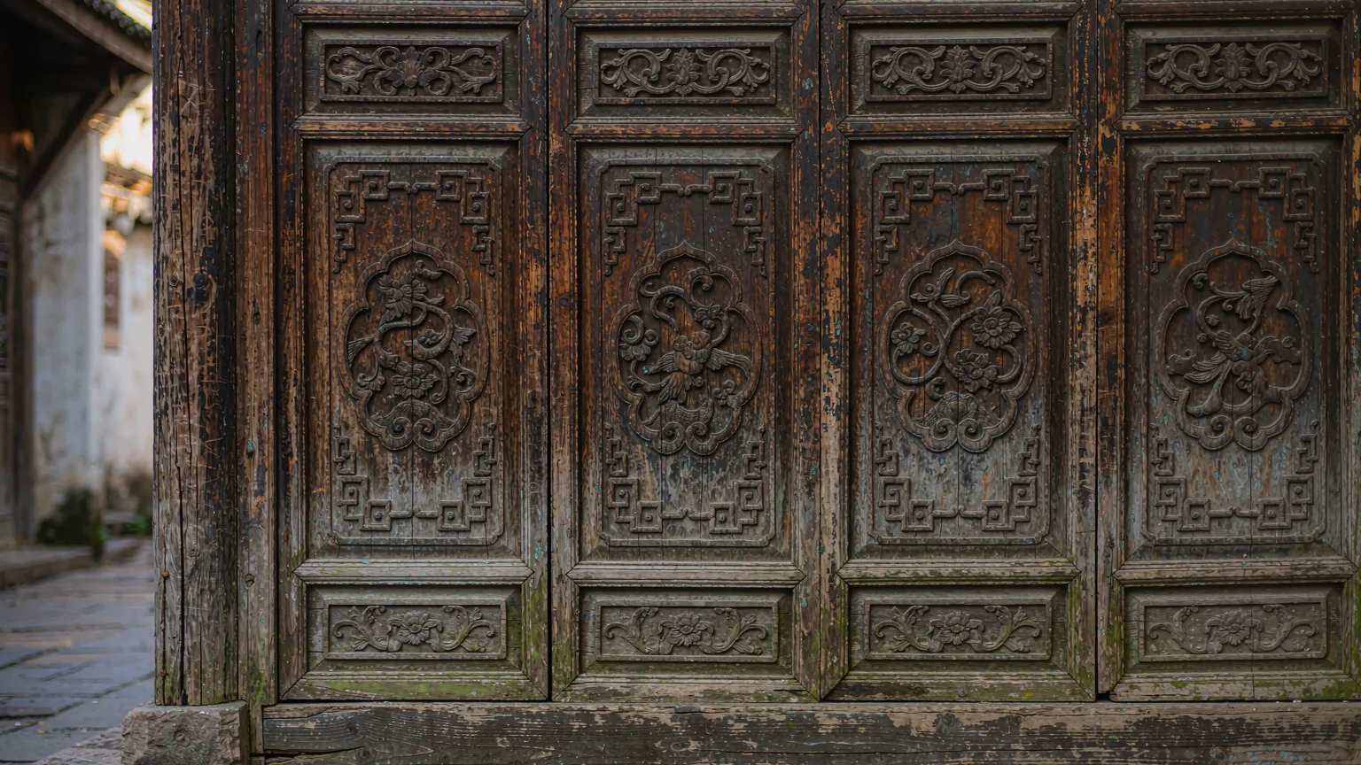 Intricate wood carving on a shophouse door in West Street Yangshuo