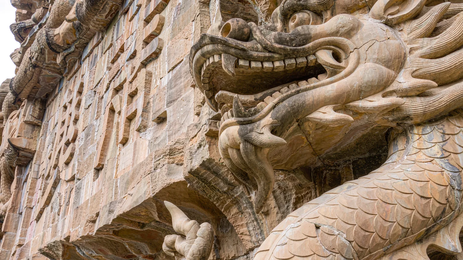 Detailed dragon carving on stone at Dragon Gate, Kunming