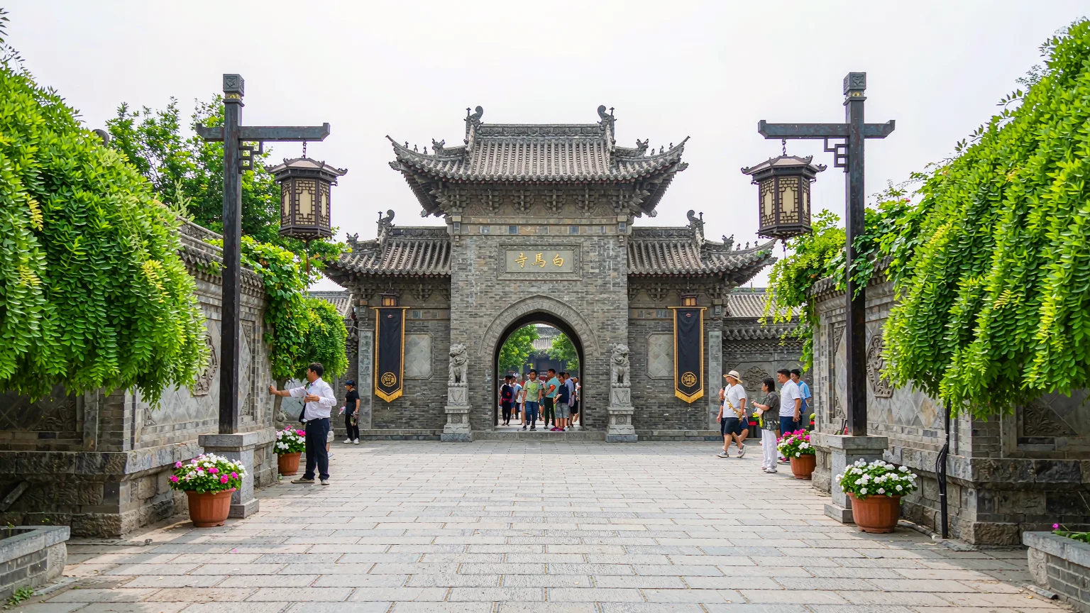 Visitors entering White Horse Temple with guide on a sunny day