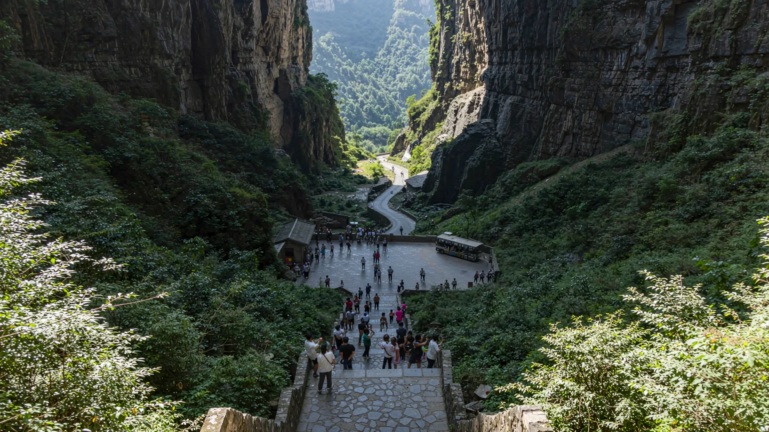 Visitors walking along stone pathway into Wulong Three Natural Bridges gorge