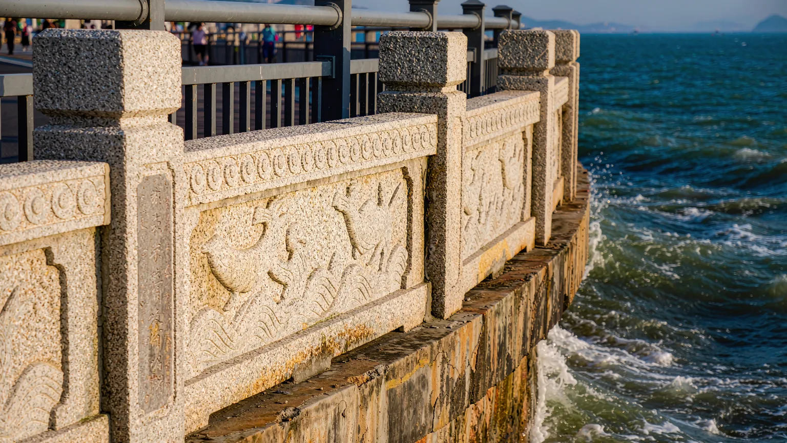 Close-up of carved stone railing on Xiamen Island Ring Road at sunset