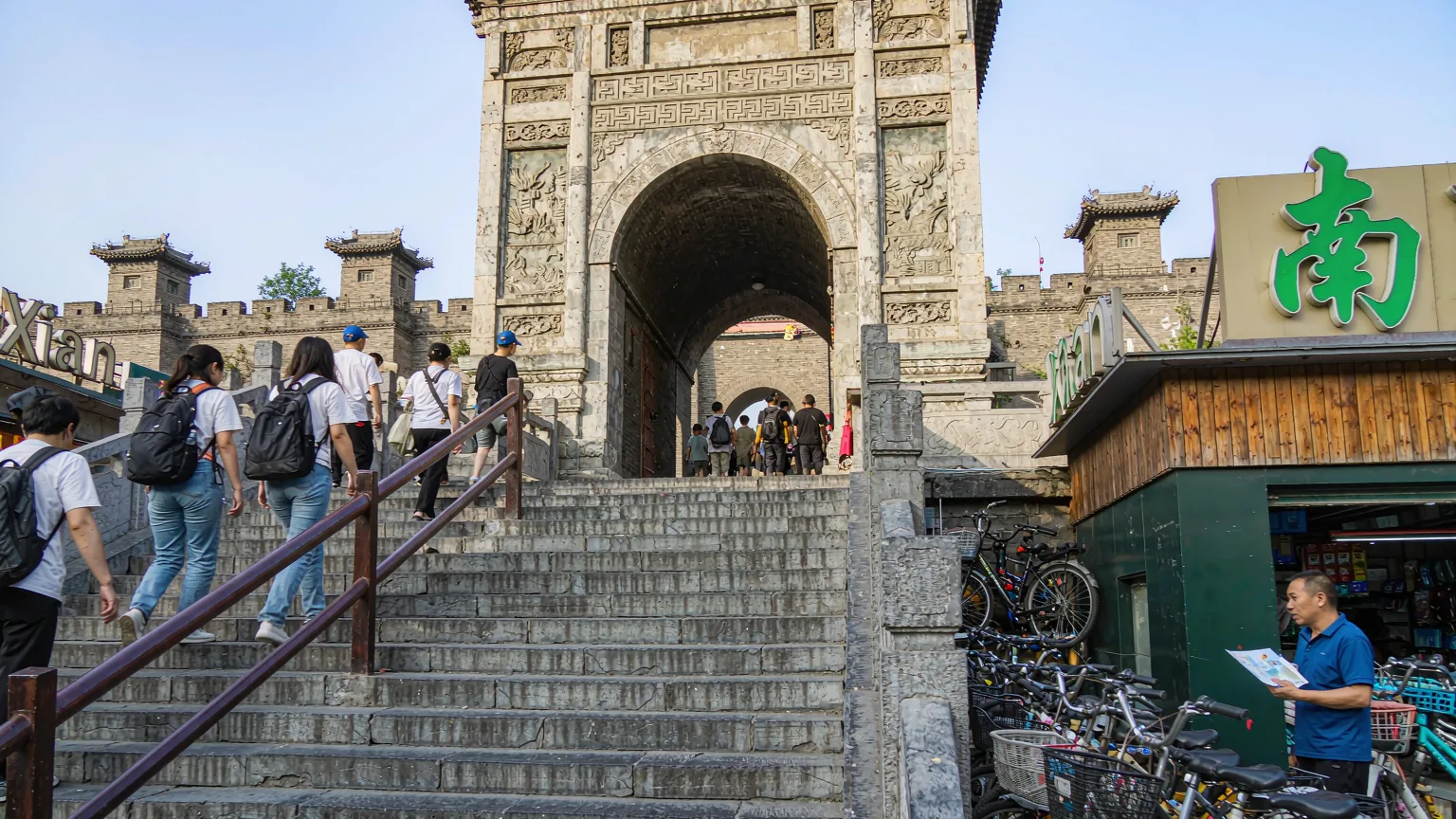Tourists climbing stairs to Xi'an City Wall at South Gate with bicycles