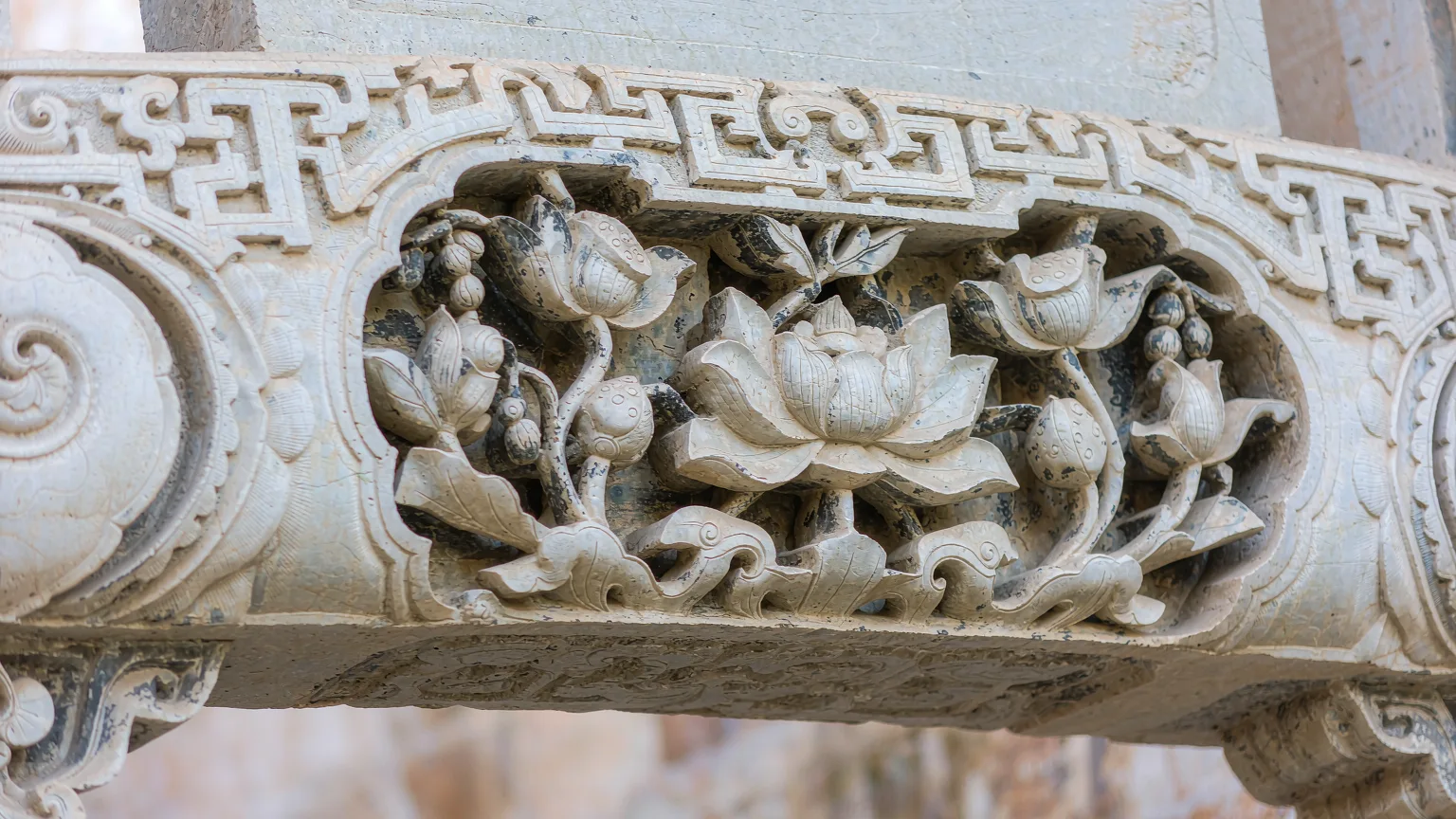 Close-up of intricate stone carvings on a Huizhou archway in Xidi