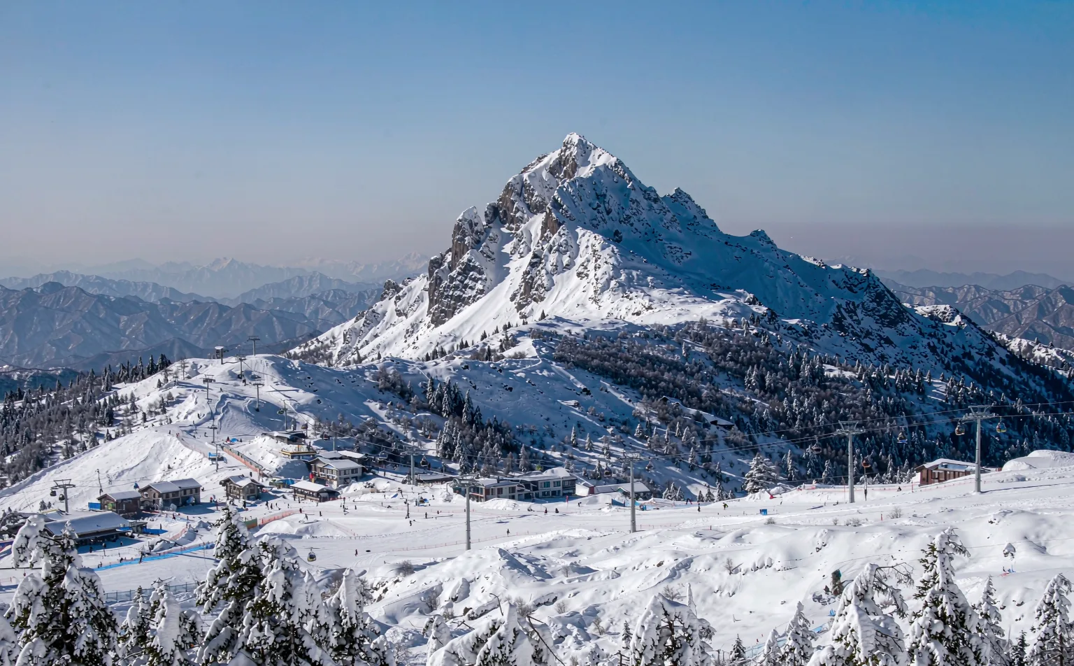 Snow covered peaks and ski resort beneath Xiling Snow Mountain