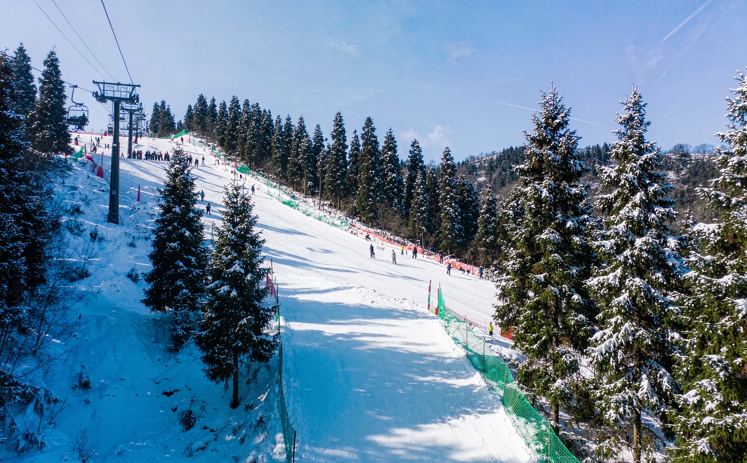 Skiers on a groomed run at Xiling Snow Mountain resort