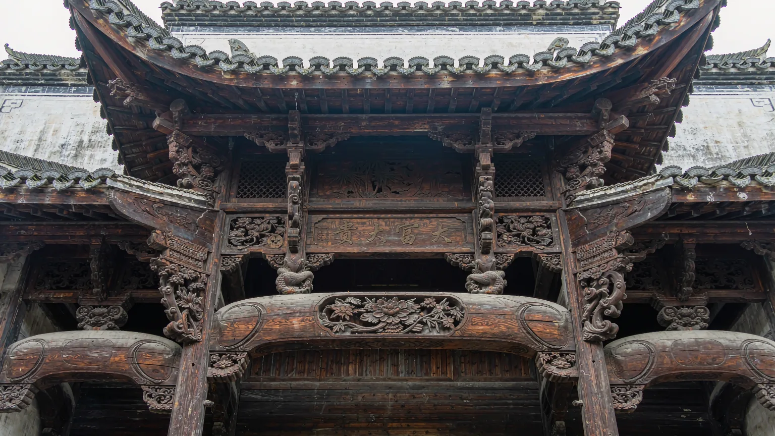Detailed wood carvings on a traditional Bai gate tower in Xizhou