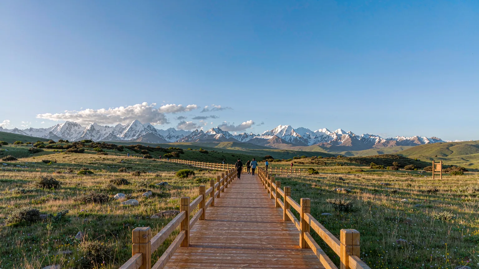 Wooden boardwalk trail through alpine meadow towards Yading peaks