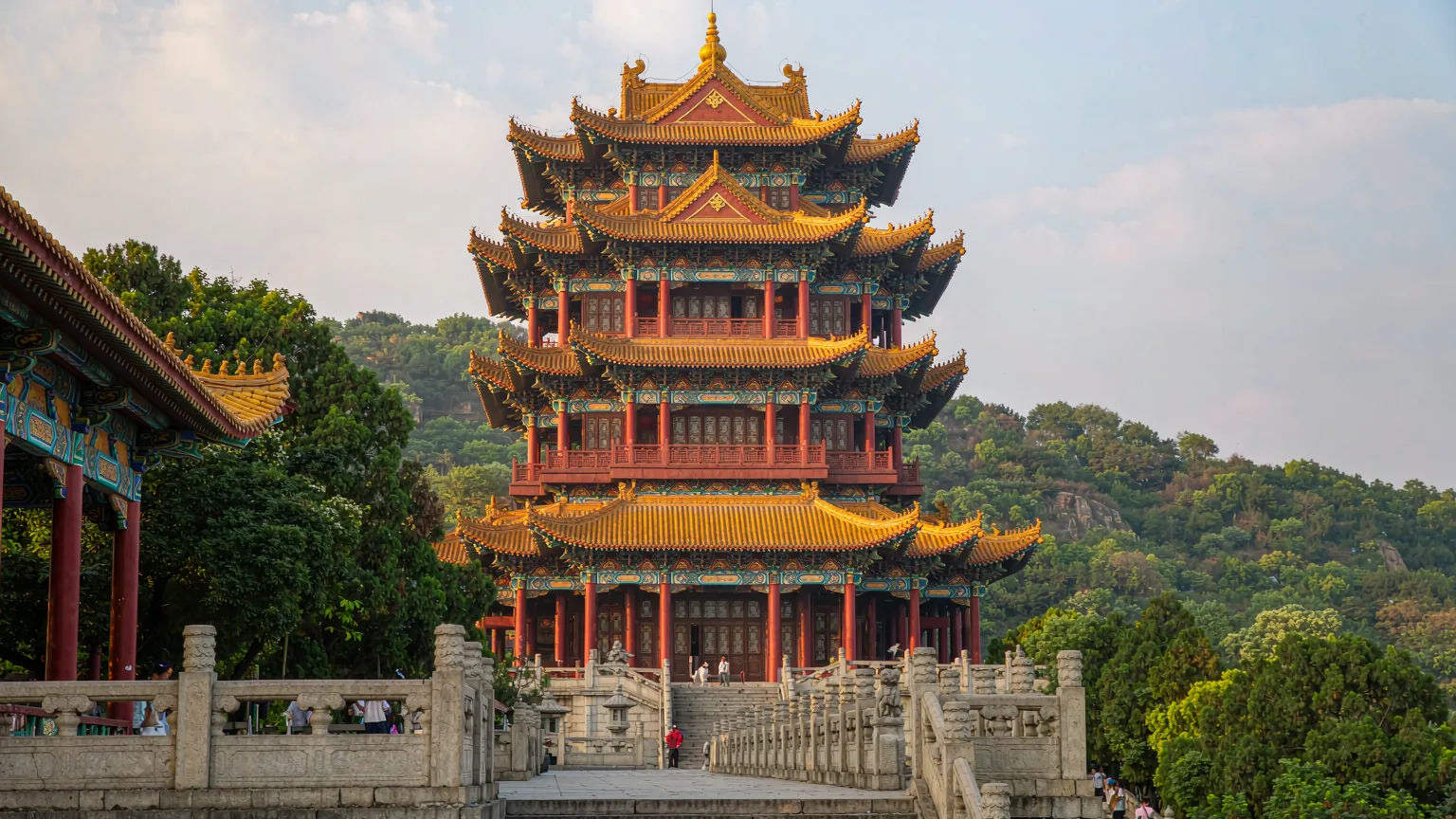 Five-story Yellow Crane Tower with golden roofs framed by Snake Hill greenery