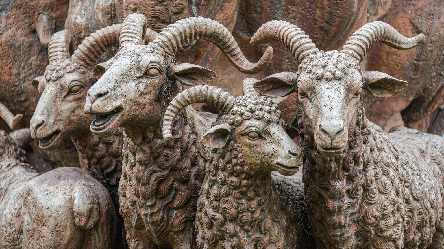Close-up of detailed stone carvings on the Five Rams Statue