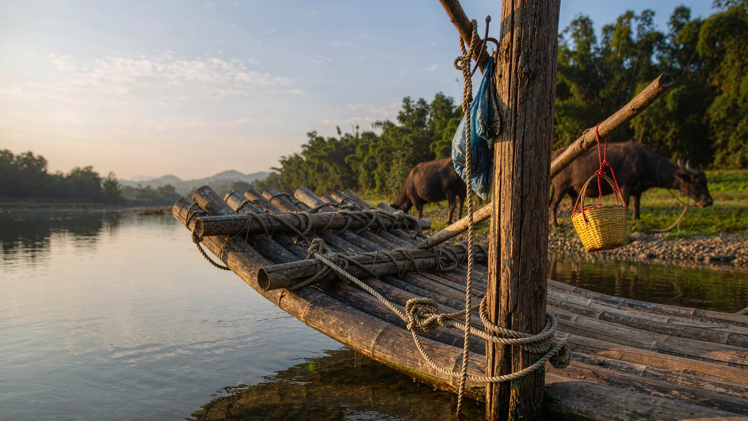 Close-up of bamboo raft tied to post on Yulong River