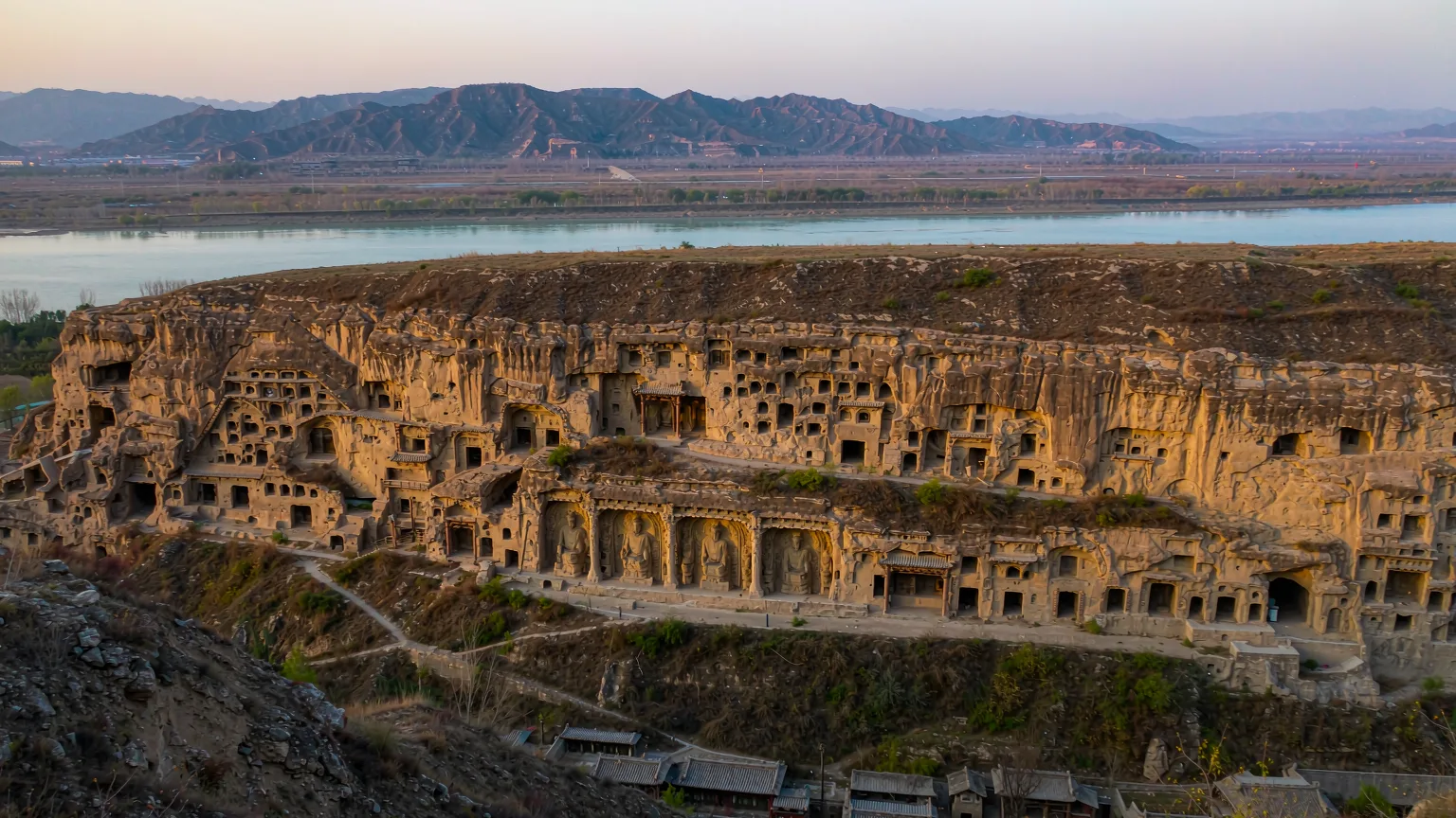 Panoramic view of Yungang Grottoes cliff face with numerous cave temples